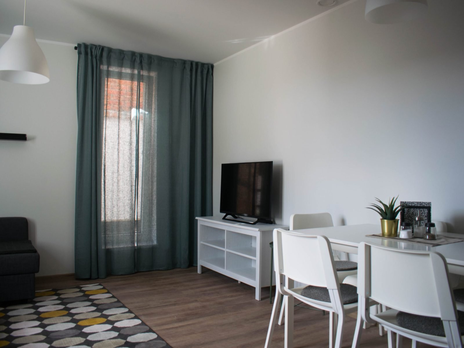 Pilt suurest heledast elutoast, televiisor ja söögiload selle kõrval.