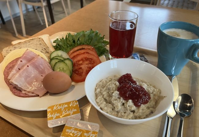 Hommikusöögi kandik, millel on puder moosiga, võileiva materjal, morss ning kohv.