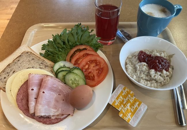 Hommikusöögi kandik, millel on puder moosiga, võileiva materjal, morss ning kohv.