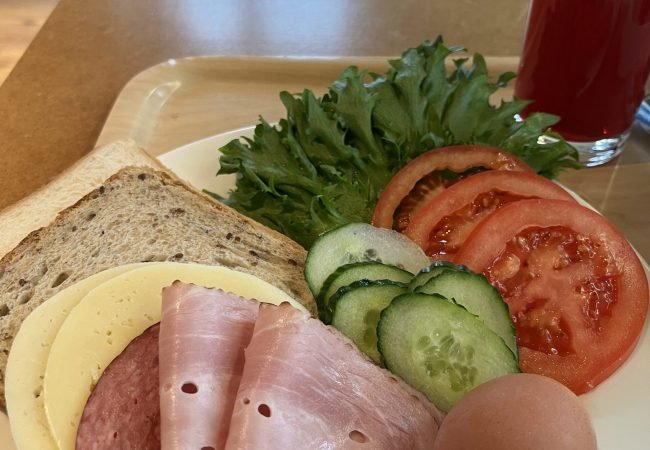 Hommikusöögi kandik, millel on puder moosiga, võileiva materjal, morss ning kohv.