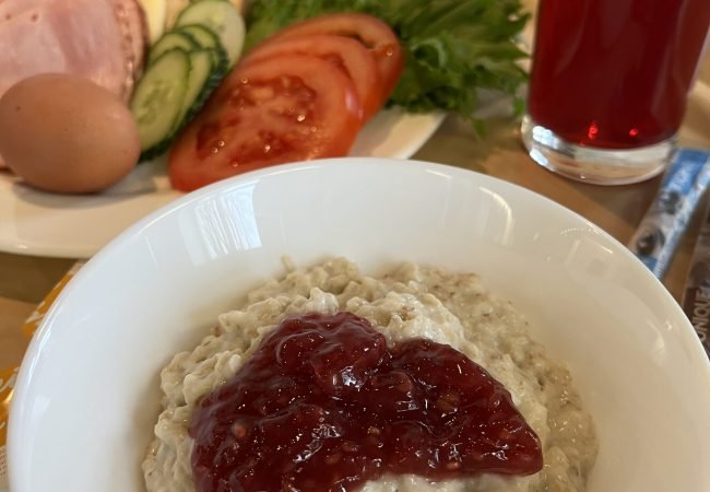 Hommikusöögi kandik, millel on puder moosiga, võileiva materjal, morss ning kohv.