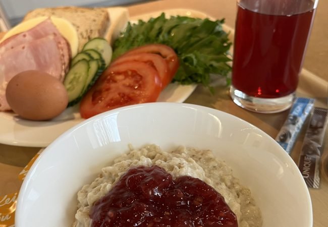 Hommikusöögi kandik, millel on puder moosiga, võileiva materjal, morss ning kohv.