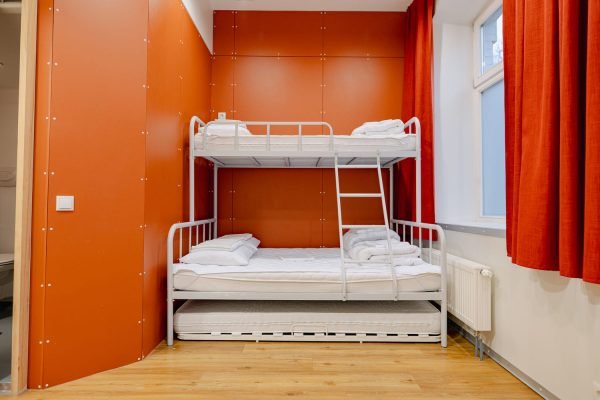 Esiplaanil narivoodi, millel ülemisel korrusel üks koht ning all 2 kohta. Taustal punane sein.