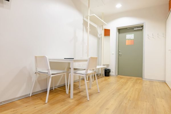 Eluttuba-esik, kus on kolmekohaline laud, riidenagid.